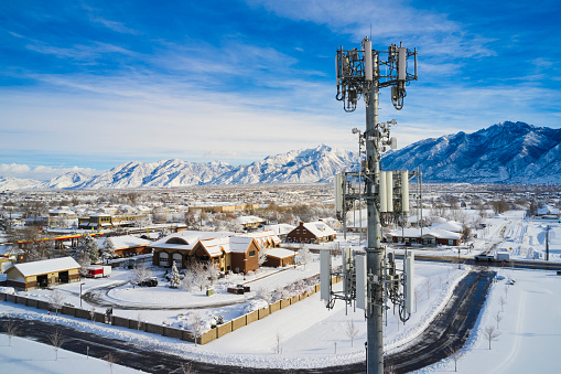 An aerial view of a communication radio tower in a suburban area in winter.