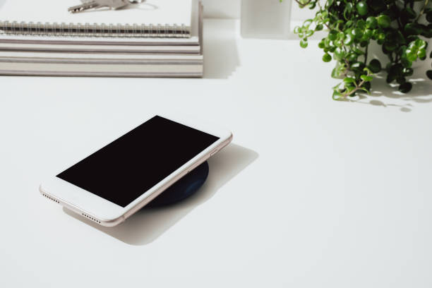 istock Smartphone Charging on a Wireless Charger at Home 1359227057
