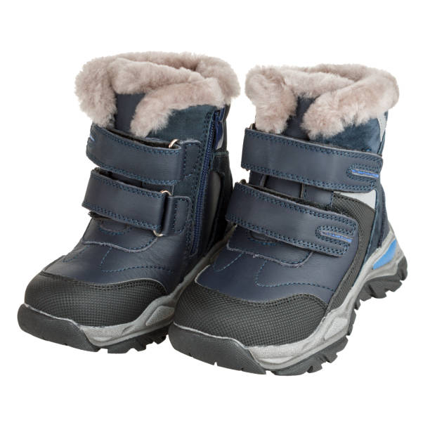 botas aisladas con piel, piel de oveja, para clima frío y nevado, impermeables, botas para niños, aisladas sobre un fondo blanco - bota de la nieve fotografías e imágenes de stock