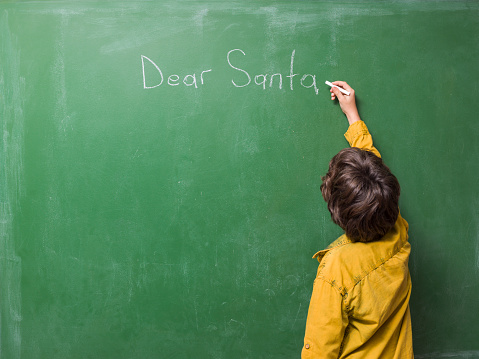 Photo of 8,5 years old elementary schoolboy writing text 