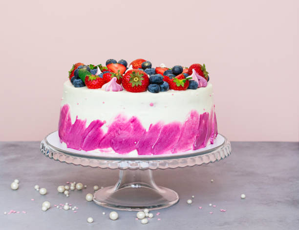 istock Delicate cake decorated with fresh berries, strawberries and blueberries on a light plain background 1359242864