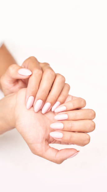 istock Classic pink wedding nail manicure on white backdrop. Spa treatment concept 1359246195