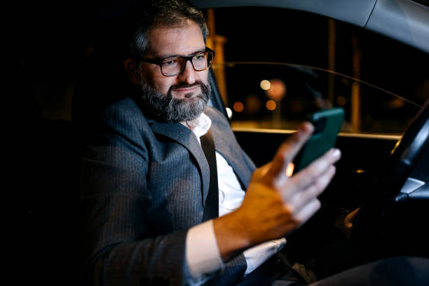 istock Businessman in suit texting from his car 1359246298