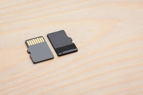 Two micro sd cards on a wooden background. Copy space.