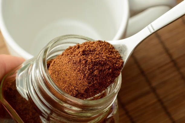 istock Man`s hand taking some ground coffee from coffee jar 1359246699