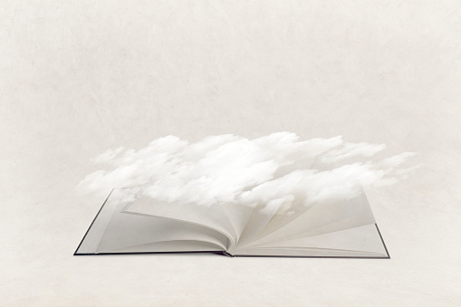 Ethereal clouds hang over the fluttering pages of an open book that conveys the concept of getting lost in literary pursuits.
