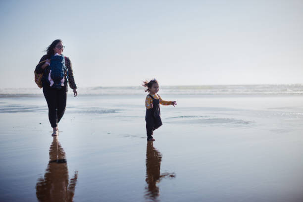 istock Family Walking on the Beach Together 1359264553
