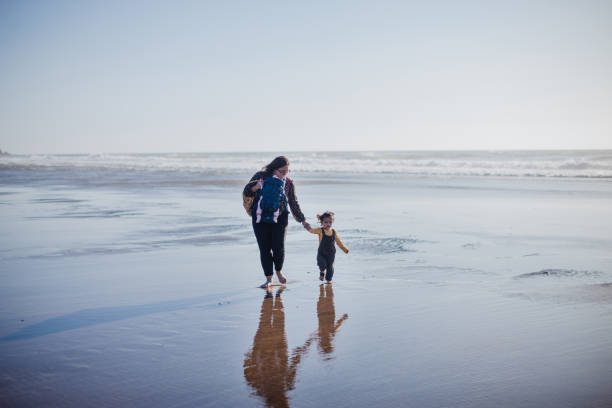istock Family Walking on the Beach Together 1359264554
