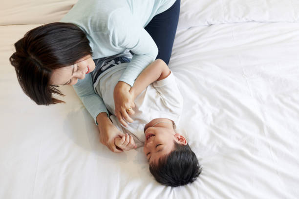 istock Mother tickling laughing son 1359266280