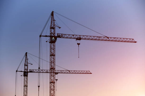 istock Silhouettes high rise cranes against blue pink sunset sky. 1359269267