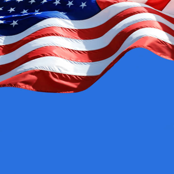 istock Close up waving American flag over clear blue sky 1359272622