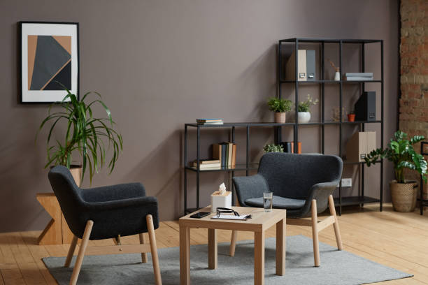 Horizontal no people shot of modern psychologist office interior in gray and brown colors with two chairs and coffee table Psychologist Office Interior mental health professional stock pictures, royalty-free photos & images