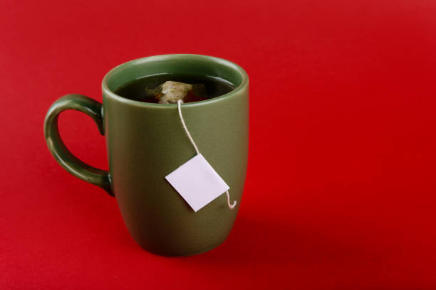 istock Cup of tea with sachet on a red background. 1359275859