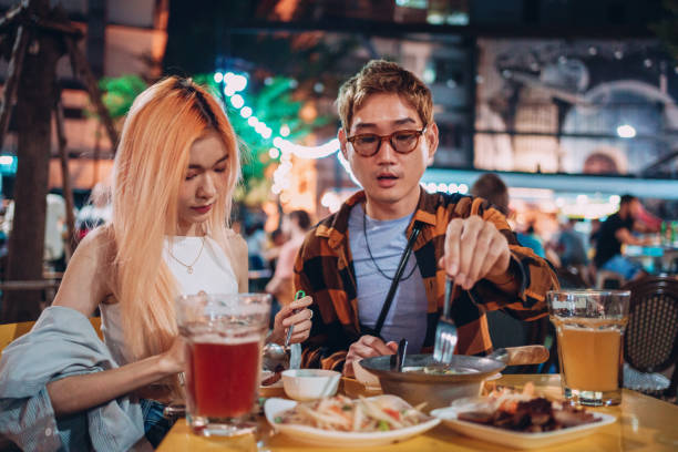 istock Friends having dinner on a night market 1359276800