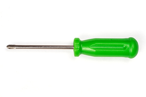 Screwdriver with green handle on a white background. Instrument close-up.