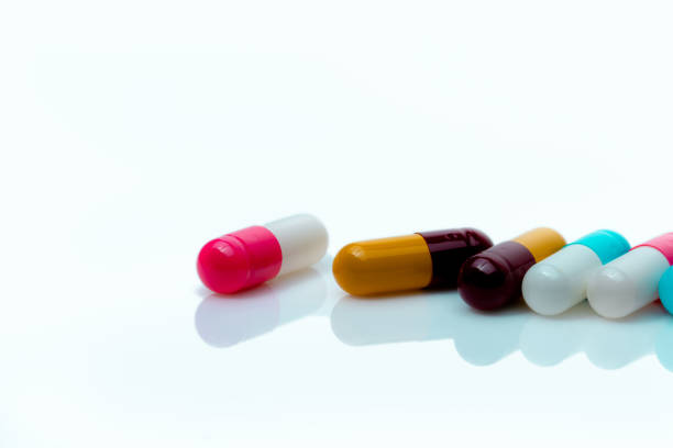 白い背景にマルチカラーの抗生物質カプセルの丸薬.抗生物質薬剤耐性.処方薬.ポリファーマシーの概念。薬局ドラッグストア製品。製薬業界。カプセル製造 - amoxicillin ストックフォトと画像