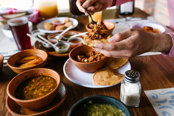 hand des mannes isst mexikanische tostadas oder tacos tortillas und traditionelles essen über dem tisch, aussicht. mexikanische küche - mexican culture food salsa mexican cuisine stock-fotos und bilder