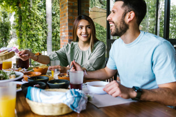 hispanic couple eating tacos and mexican food at outdoor Restaurant terrace in Mexico Latin America hispanic couple eating tacos and mexican food at outdoor Restaurant terrace in Mexico Latin America clingy girlfriend stock pictures, royalty-free photos & images
