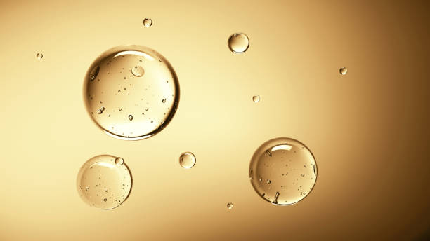 Transparent bubbles float in yellow background Many water bubbles on shaded golden surface float together. Golden background template with round particles massage oil photos stock pictures, royalty-free photos & images