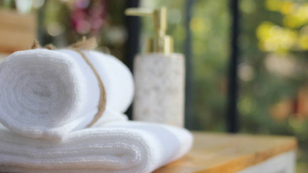 istock close up ofTowel placed on basket, white table top, bottle of liquid soap, spa set for bathing in the bathroom, copy space, bathroom window. 1359289334