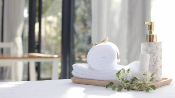istock Roll up of white towels on white table with copy space Spa concept 1359289384
