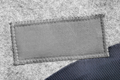 Empty textile patch on textile background closeup