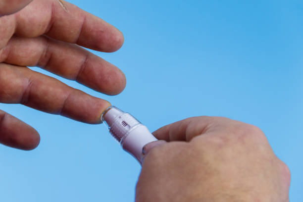 istock Man taking blood sample with lancet pen. Diabetes concept 1359292388