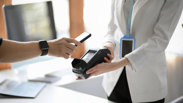 istock A female receptionist accepts a customer's payment from a payment terminal 1359296310
