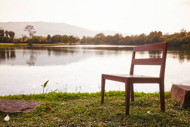 Wooden chairs at pond, at evening