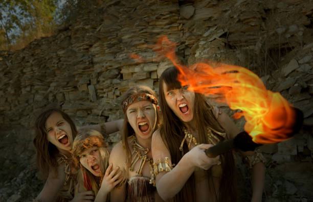 istock Angry Neanderthal Girls With A Blazing Torch 1359296836