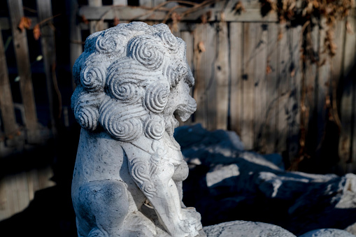 stone lion statue in sunlight, in an old park