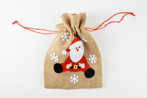 Burlap Santa Claus gift bag with Christmas ornaments on the white background