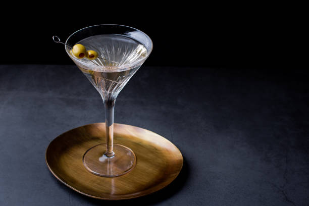 暗いテーブルにオリーブを飾ったマティーニグラスの汚れたマティーニカクテル - martini martini glass dirty martini olive ストックフォトと画像