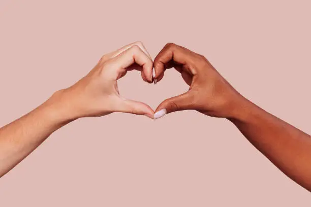 Photo of Black and white female hands in heart shape