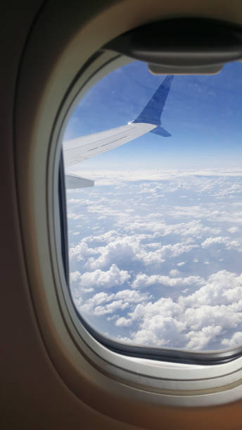 istock Clouds and sky as seen through window of an aircraft 1359302173