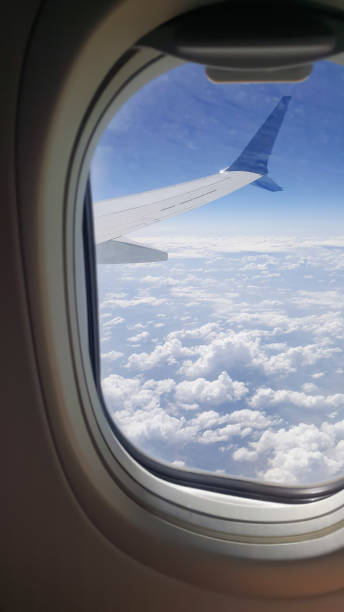 istock Clouds and sky as seen through window of an aircraft 1359302192