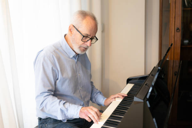 istock Old man play on piano at home 1359302565