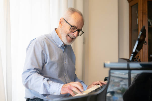 istock Old man play on piano at home 1359302604