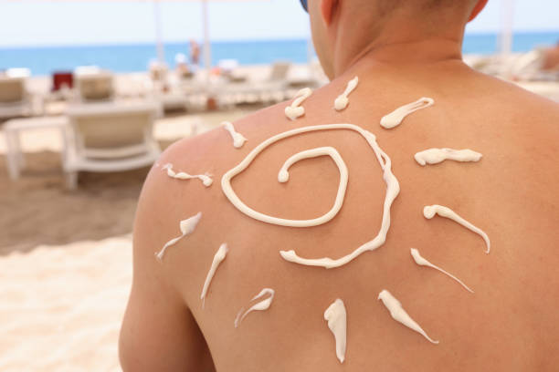 istock Sun painted with sunscreen on back of man closeup 1359302899