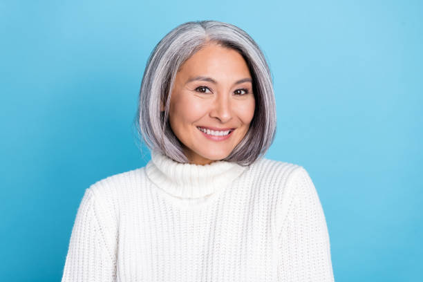 foto de la mujer bonita mayor de buen humor sonrisa dentada clínica de cuidado bucal aislada sobre fondo de color azul - mature women fotografías e imágenes de stock