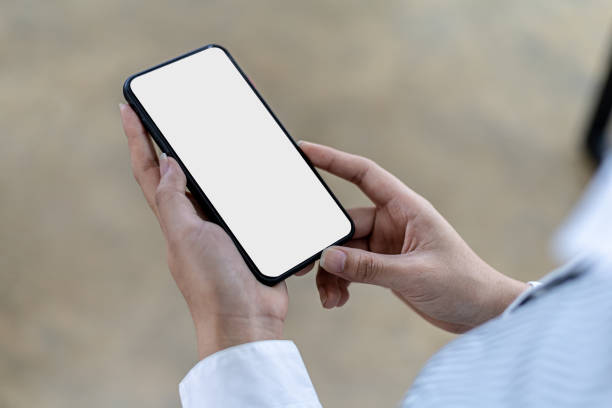 istock Smartphone blank screen, person holding smartphone and looking at blank screen, mockup screen for further editing can be used in a variety of tasks. copy space. 1359305763
