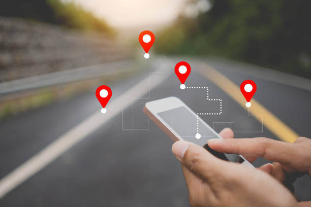 istock Man hand using smart phone with navigator location point at street background. 1359307098