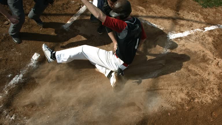 Overhead view of baseball player sliding into home plate