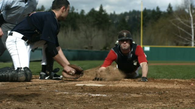 Baseball player slides into home plate, slow motion