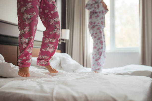 istock Girls jumping on bed in pajamas 1359312093