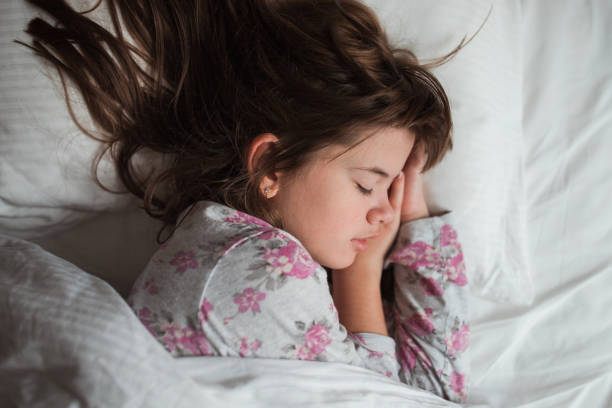 Cute young girl sleeping in a bed