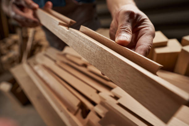 Focused photo on wooden bar being in hand Professional joiner standing at workshop and manufacturing furniture for sale carpentry stock pictures, royalty-free photos & images