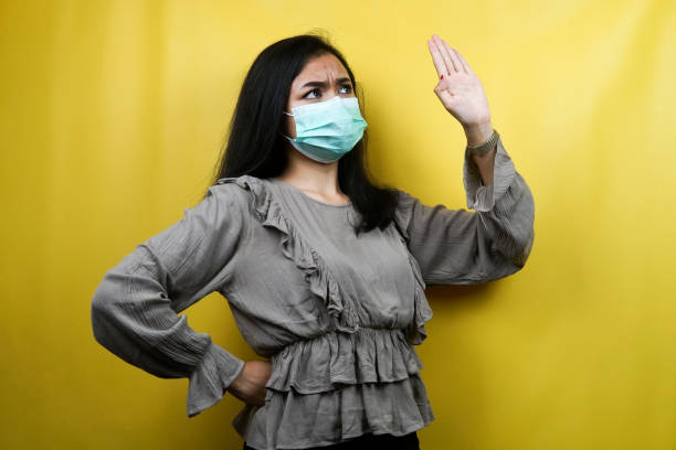 istock Beautiful young woman wearing a mask with open arms, refusing something, isolated 1359313429