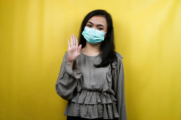 Beautiful young woman wearing a mask saying hello how are you isolated stock photo