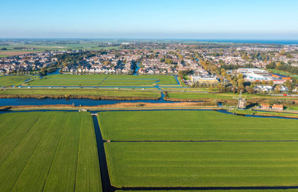 istock Typical Dutch polder landscape with windmill and dutch village 1359314900